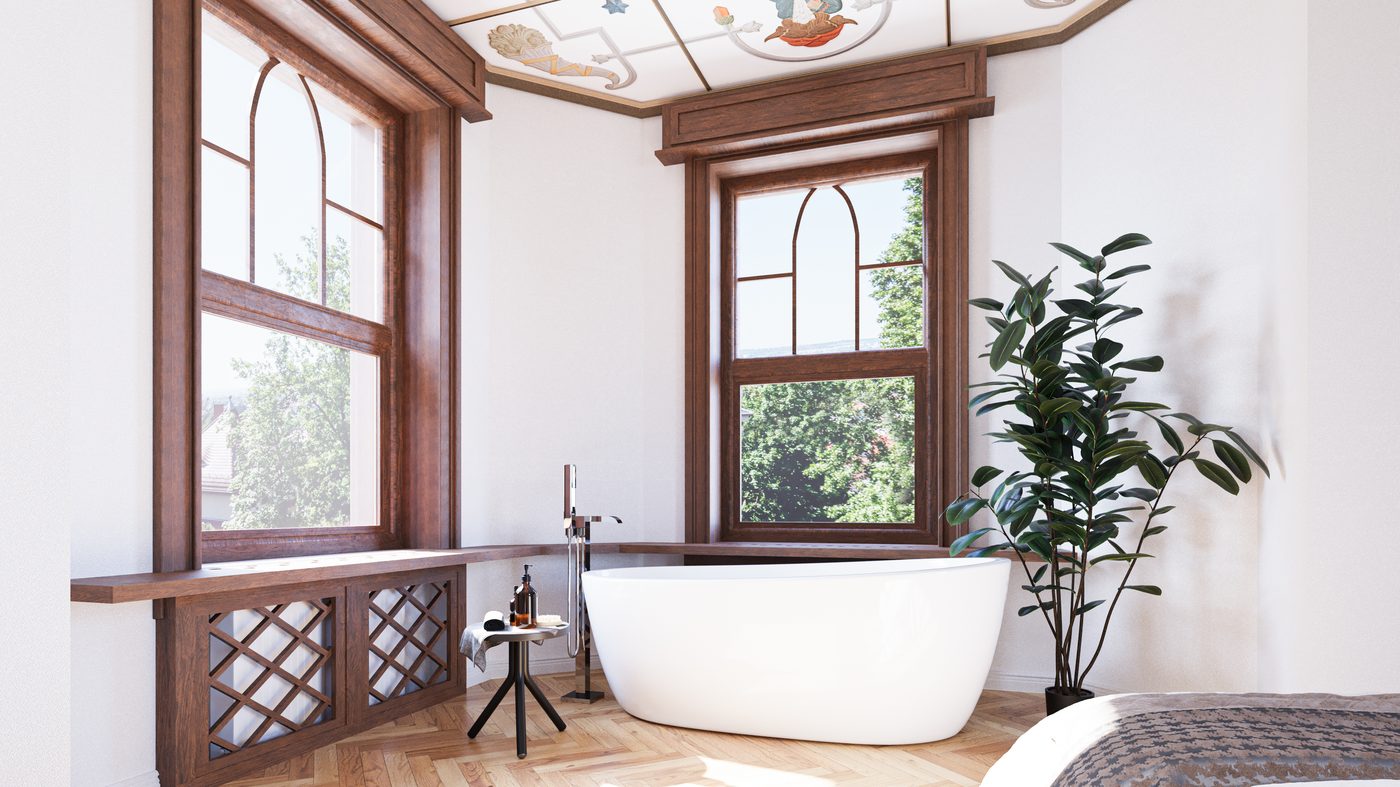 Badezimmer mit freistehender Wanne vor historischen Bleiglasfenstern